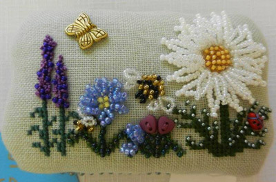 Small rectangular box with a padded lid, linen with beaded flowers in whites and mauves, a beaded bee, butterfly charm and cross-stitch leaves