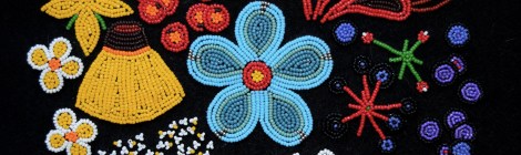 artwork of colourful beaded flowers, leaves and fruit on a black backgorund