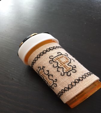 pill bottle with embroidered sleeve