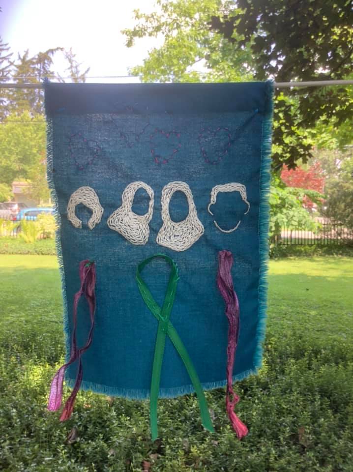 blue flag with 4 head silhouettes in white