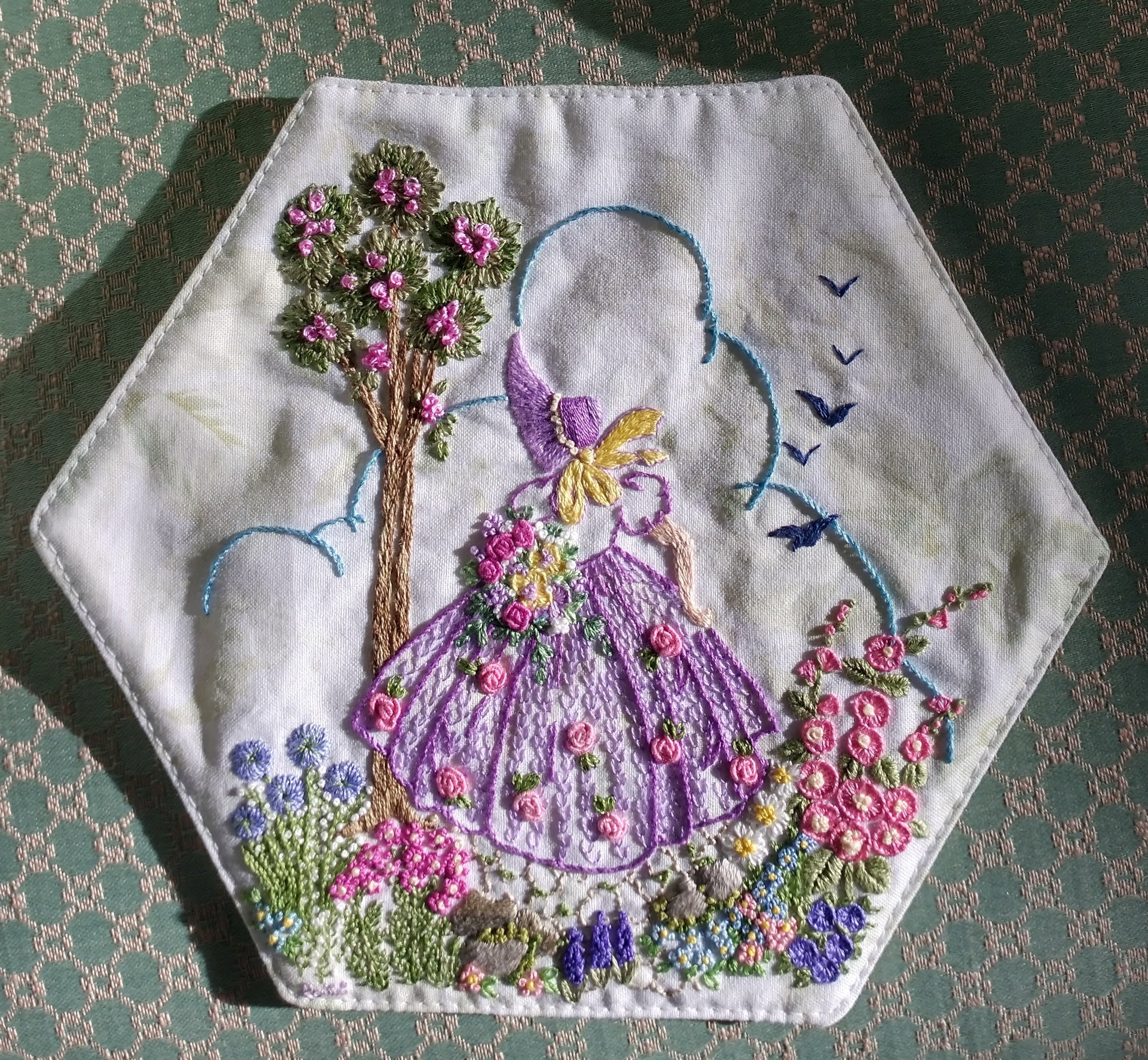 woman in lavender dress with flora done in surface embroidery