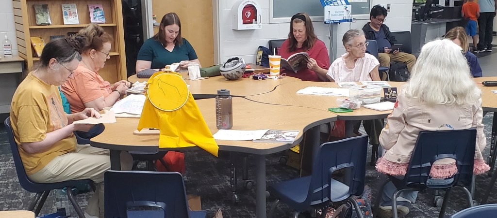 stitchers at tables in the library