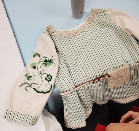 a blouse with Deerfield embroidery, in green, on the sleeve