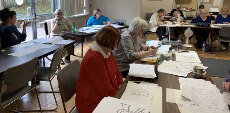 stitchers, designing their illuminated letters on paper