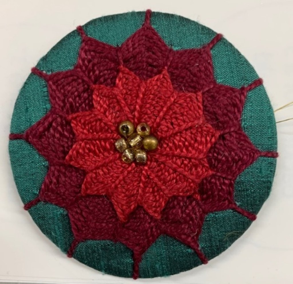 green medallion covered in red needlelace like at Poinsettia
