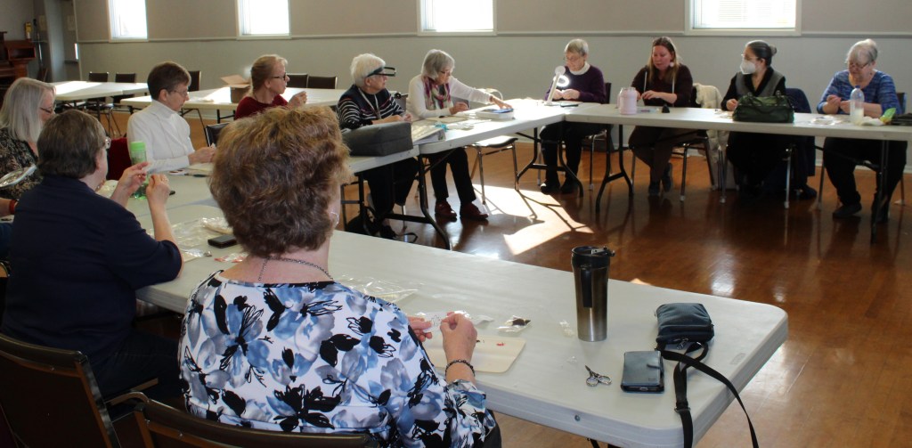11 women embroidering at tables