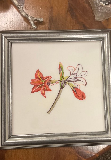 framed, embroidered image of amaryllis flowers on a stalk