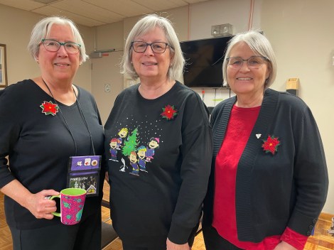 3 women wearing poppy brooches