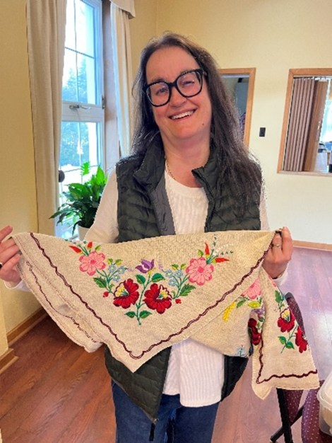 woman holding a cloth embroidered with flowers