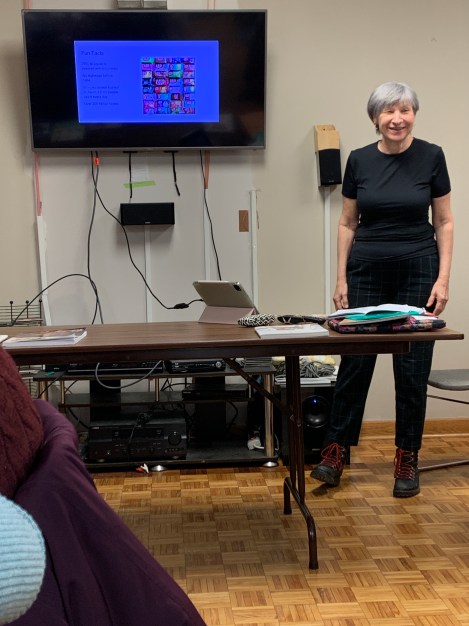 a woman standing beside a projection screen