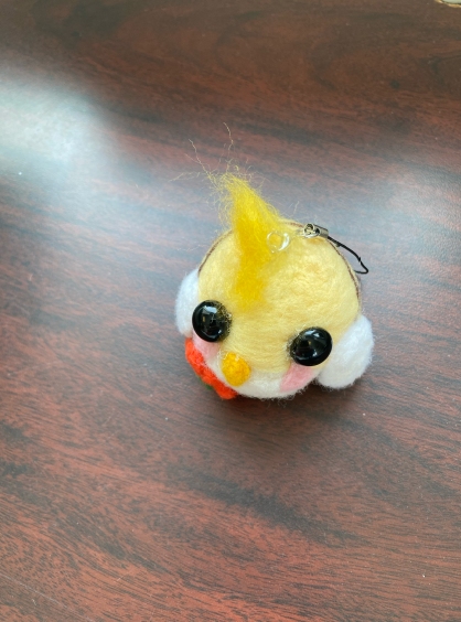 a chick done in needlefelting with large, black, bead eyes