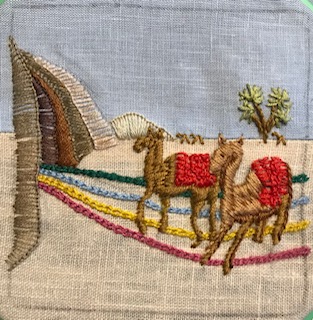 embroidery of 2 camels approaching some hills