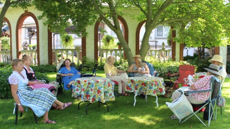 women at outdoor tables with flowered tablecloths